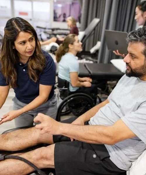 A woman helping a man in exercise